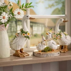 Dekofigur Gans mit Blumenkranz aus Magnesia seitlicher Blick